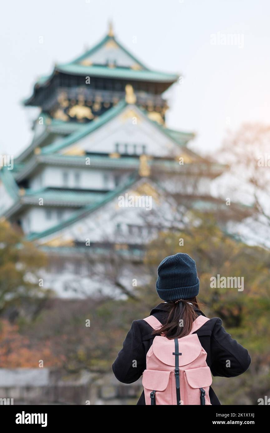solo woman tourist trveling at Osaka castle in Autumn season, Asian traveler visit in Osaka city, Japan. Vacation, destination and travel concept Stock Photo