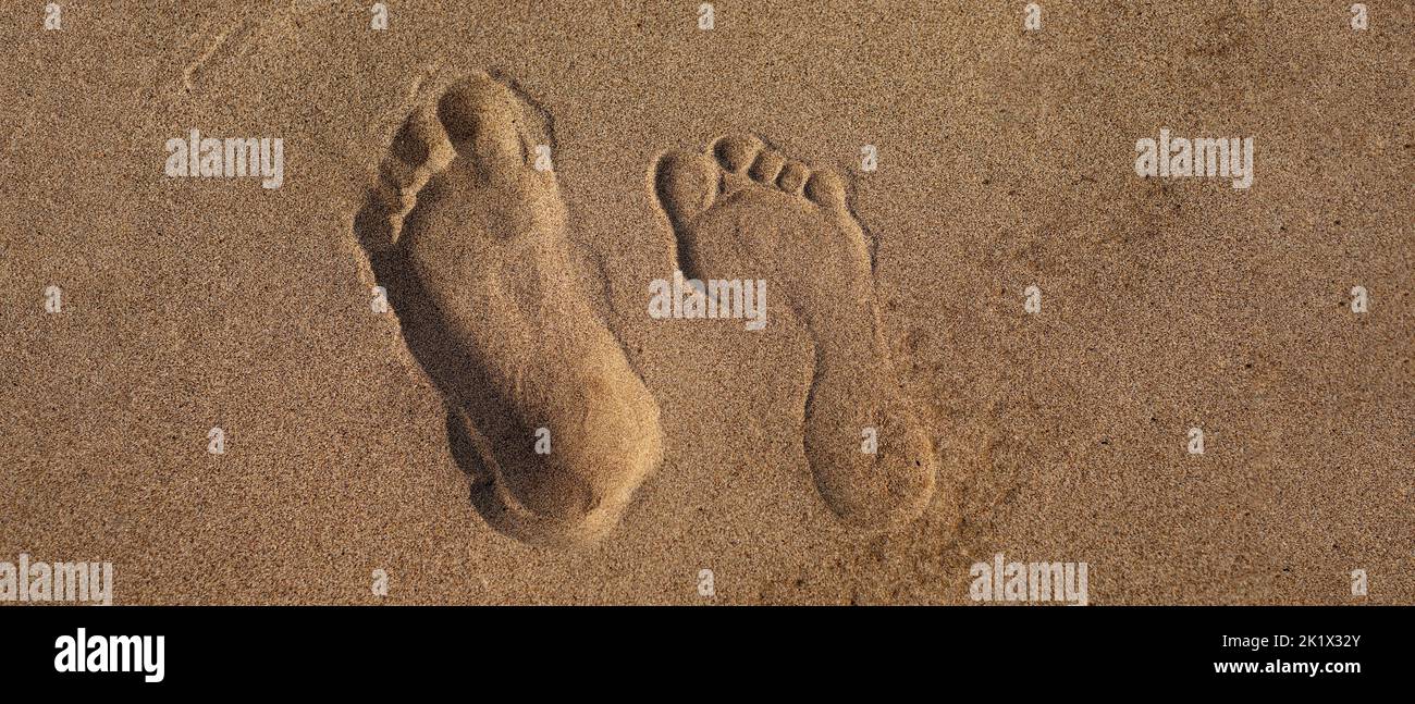 Male and female footprint footsteps on sand. Concept walking barefoot