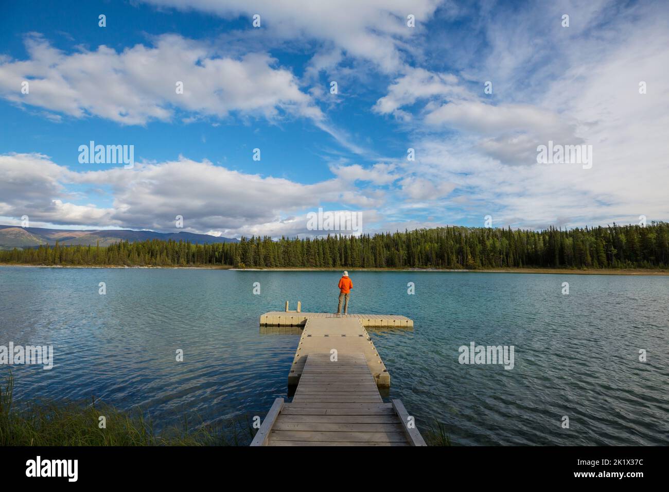 A man is resting at ease by the calm lake. Relaxation vacation Stock Photo