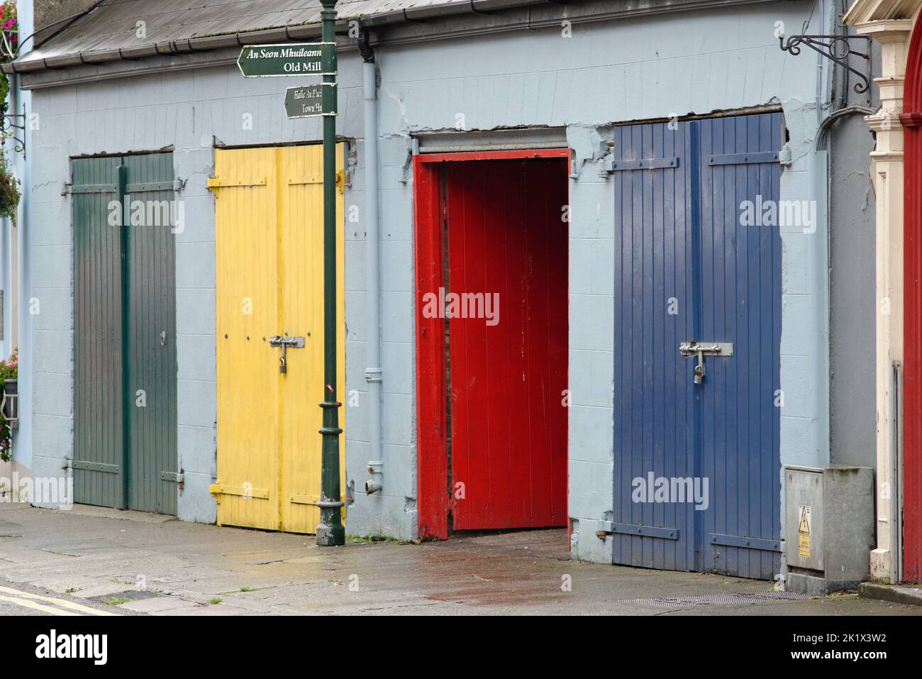 Multicoloured wooden doors in a small town in the Irish Republic. Green, yellow, red and blue. Stock Photo