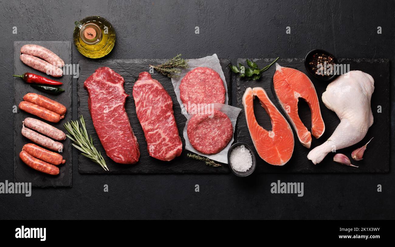 Various raw meat and fish. Steaks, sausages, salmon, chicken and spices. Flat lay Stock Photo