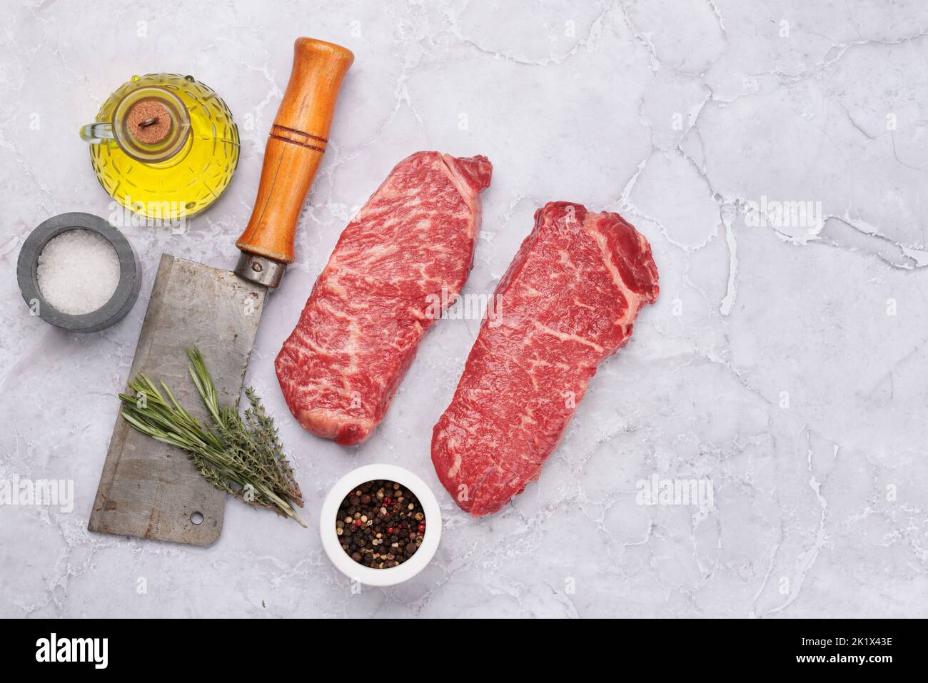 Prime marbled beef steaks and spices. Raw striploin steak. Flat lay with copy space Stock Photo