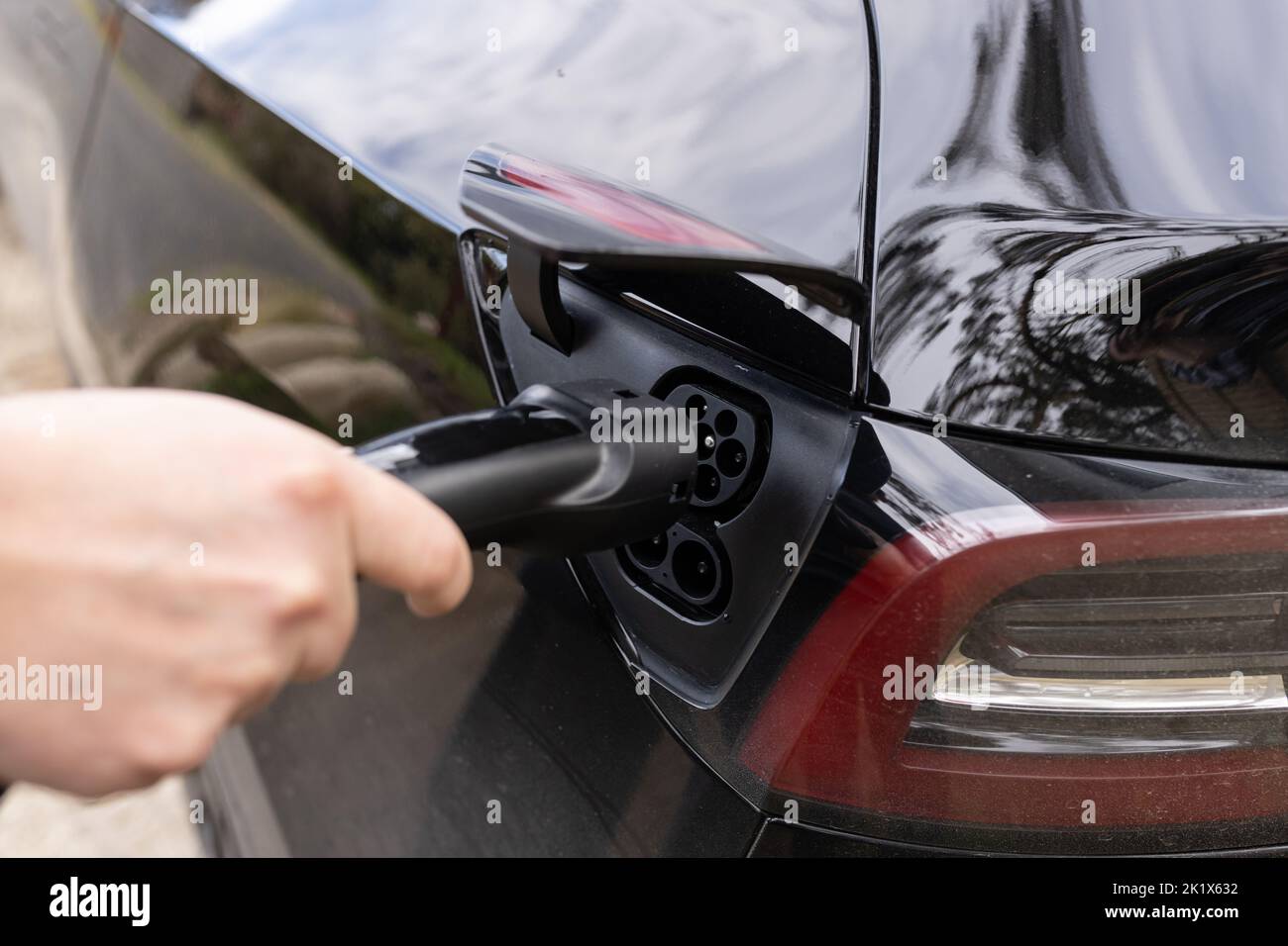 A close up of a EV charger plug being plugged into an electric vehicle