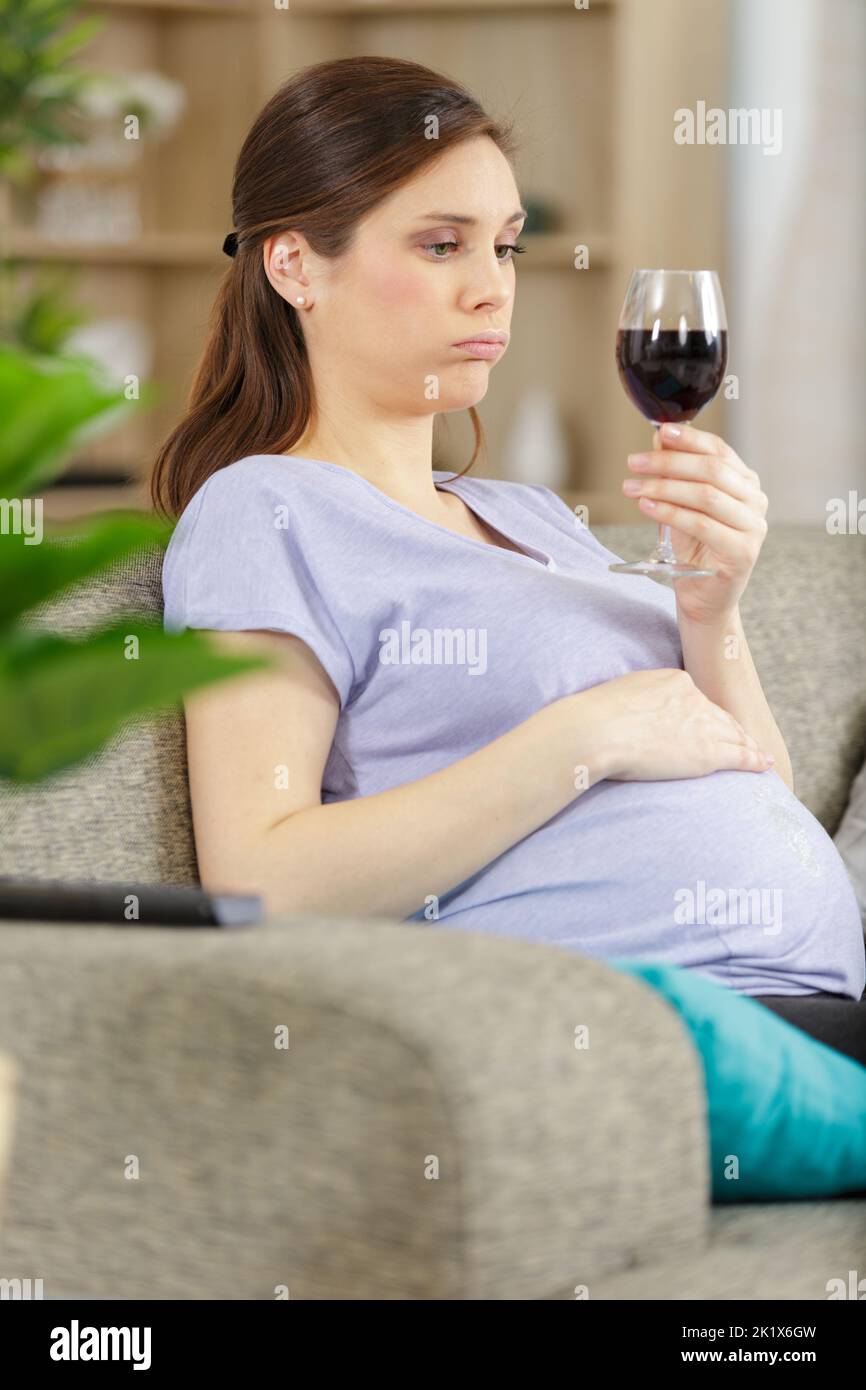 pregnant woman holding a glass of wine Stock Photo