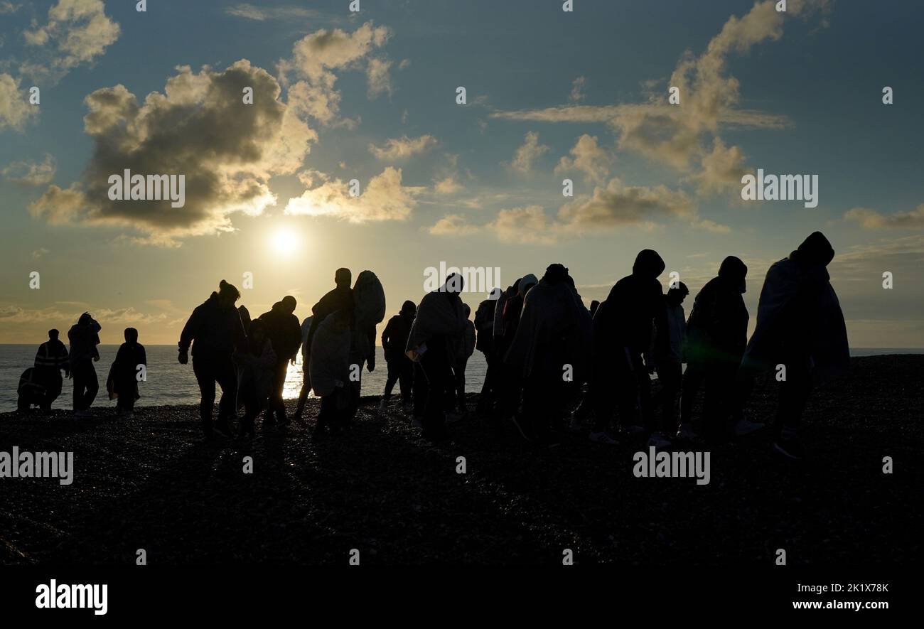 A group of people thought to be migrants walk up the beach in Dungeness, Kent, after being rescued in the Channel by the RNLI following following a small boat incident. Picture date: Wednesday September 21, 2022. Stock Photo