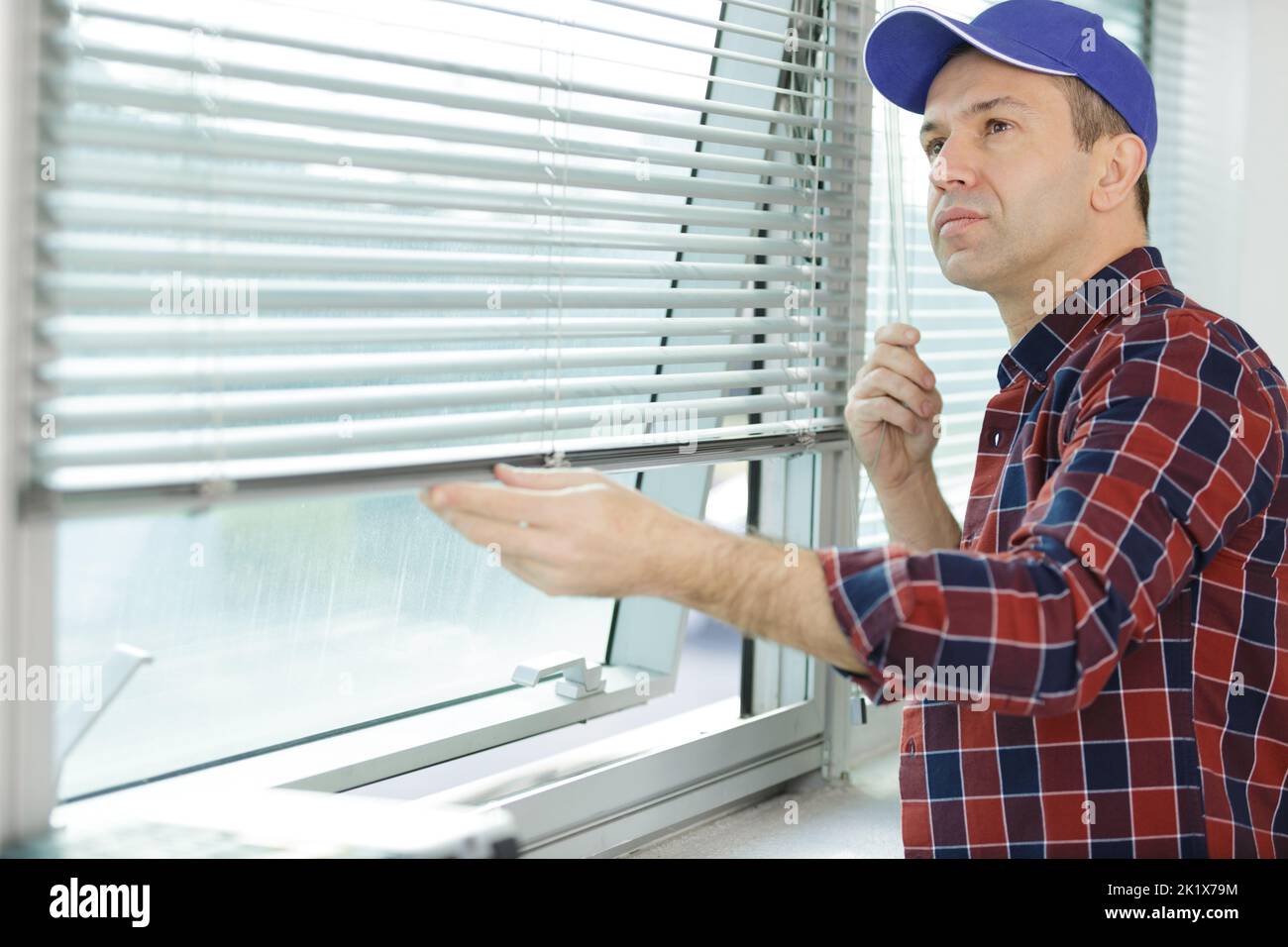 man installing window blinds at home Stock Photo