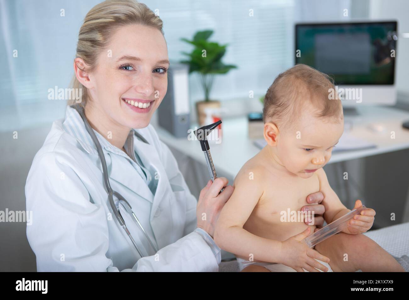 female pediatrician with baby for routine healthcare checkup Stock