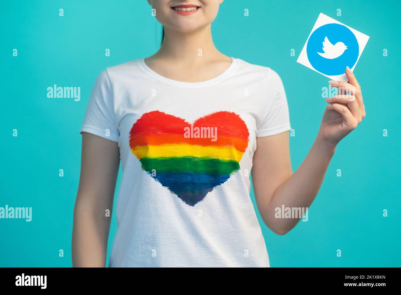 Kharkiv, Ukraine - November 27, 2020: Twitter logo. Social network. Online blog. Internet community. Woman in heart like shirt hand showing mobile app Stock Photo