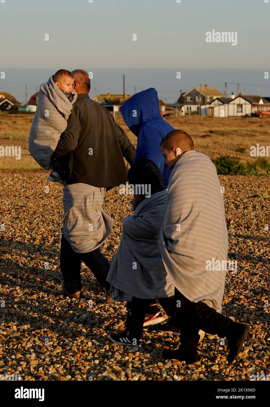 EDITORS NOTE: The PA Picture Desk has been unable to gain the necessary permission to photograph children under 16 on issues involving their welfare. This image has been provided unpixelated for customers to pixelate in their own style. A group of people thought to be migrants walk up the beach in Dungeness, Kent, after being rescued in the Channel by the RNLI following following a small boat incident. Picture date: Wednesday September 21, 2022. Stock Photo