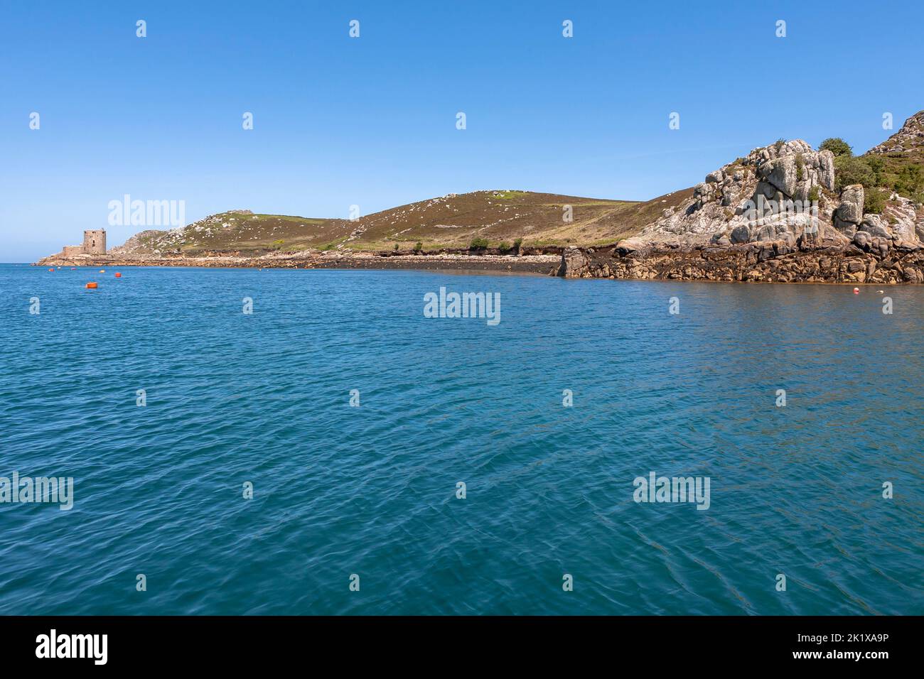 Cromwell's Castle on the island of Tresco, from New Grimsby Sound between Tresco and Bryher, Isles of Scilly, UK on a calm Summer's day. Stock Photo