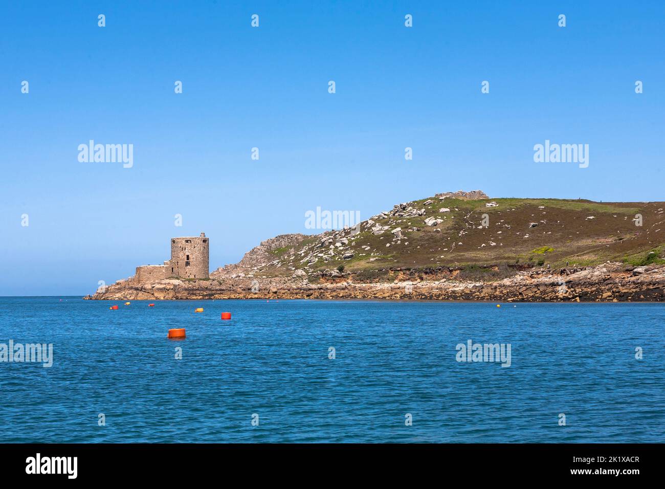 Cromwell's Castle by the shore and the ruins of King Charles's Castle above: Tresco, Isles of Scilly, UK Stock Photo