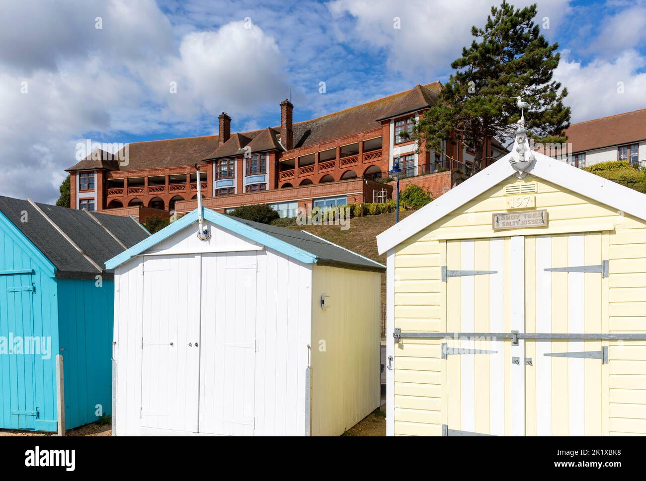 Colourful beach huts on seafront, Barlet Hospital building behind, Felixstowe, Suffolk,  England, UK Stock Photo