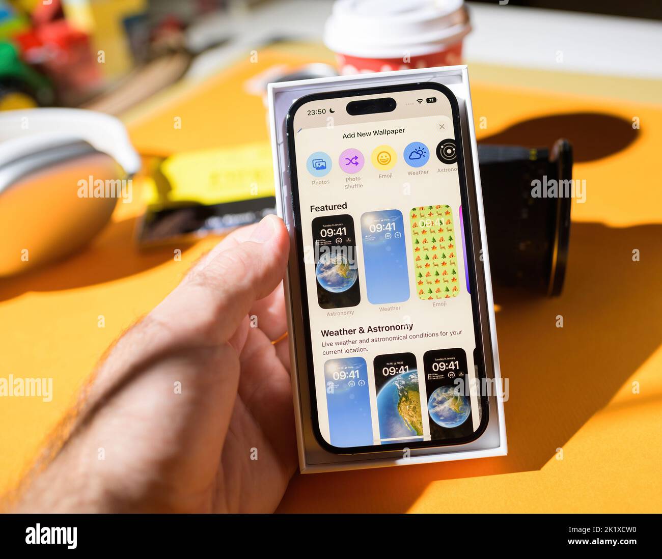Paris, France - Sep 17, 2022: Add new wallpaper menu section with featured and weather astronomy categories iOS 16 on iPhone 14 Pro by Apple Computers unboxing in male hand Stock Photo