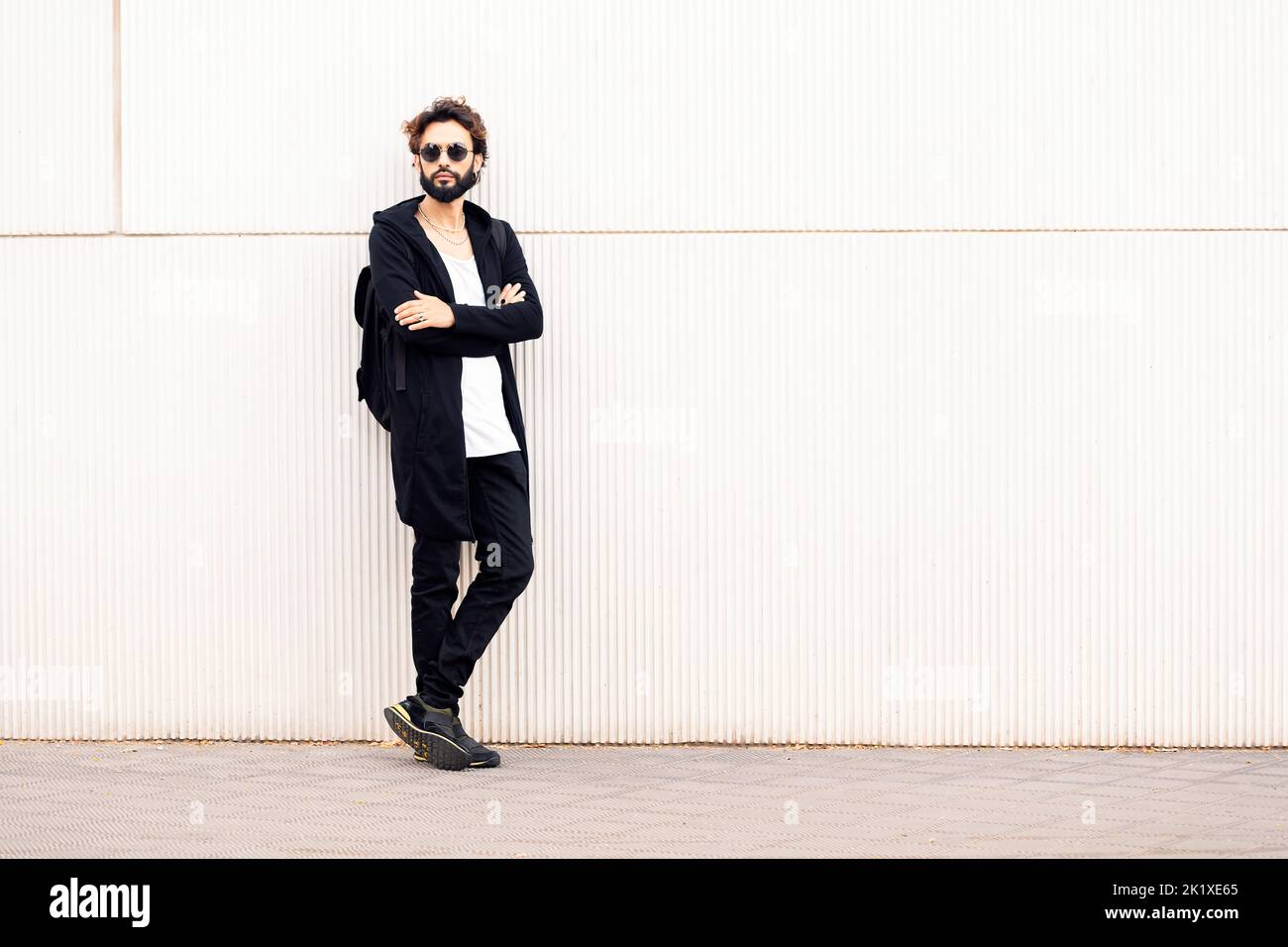 young man with sunglasses leaning in a white wall Stock Photo - Alamy