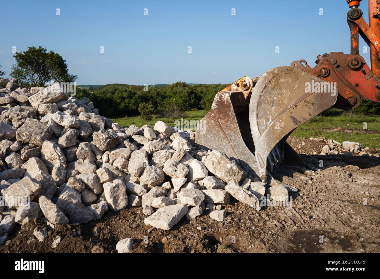 rocks of stone building being digged by excavator bucket Stock Photo ...