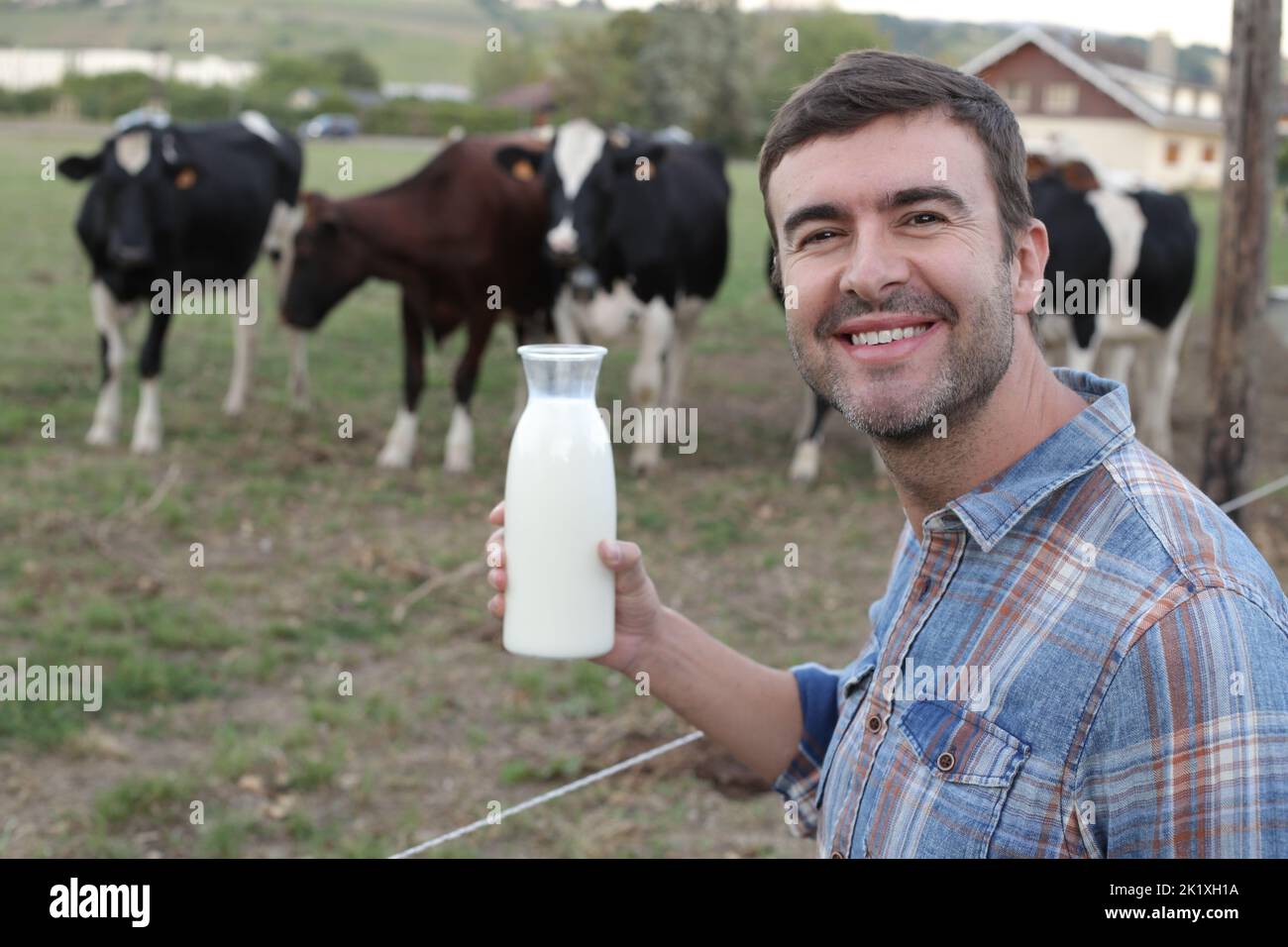 Farmer with cows in the background Stock Photo - Alamy