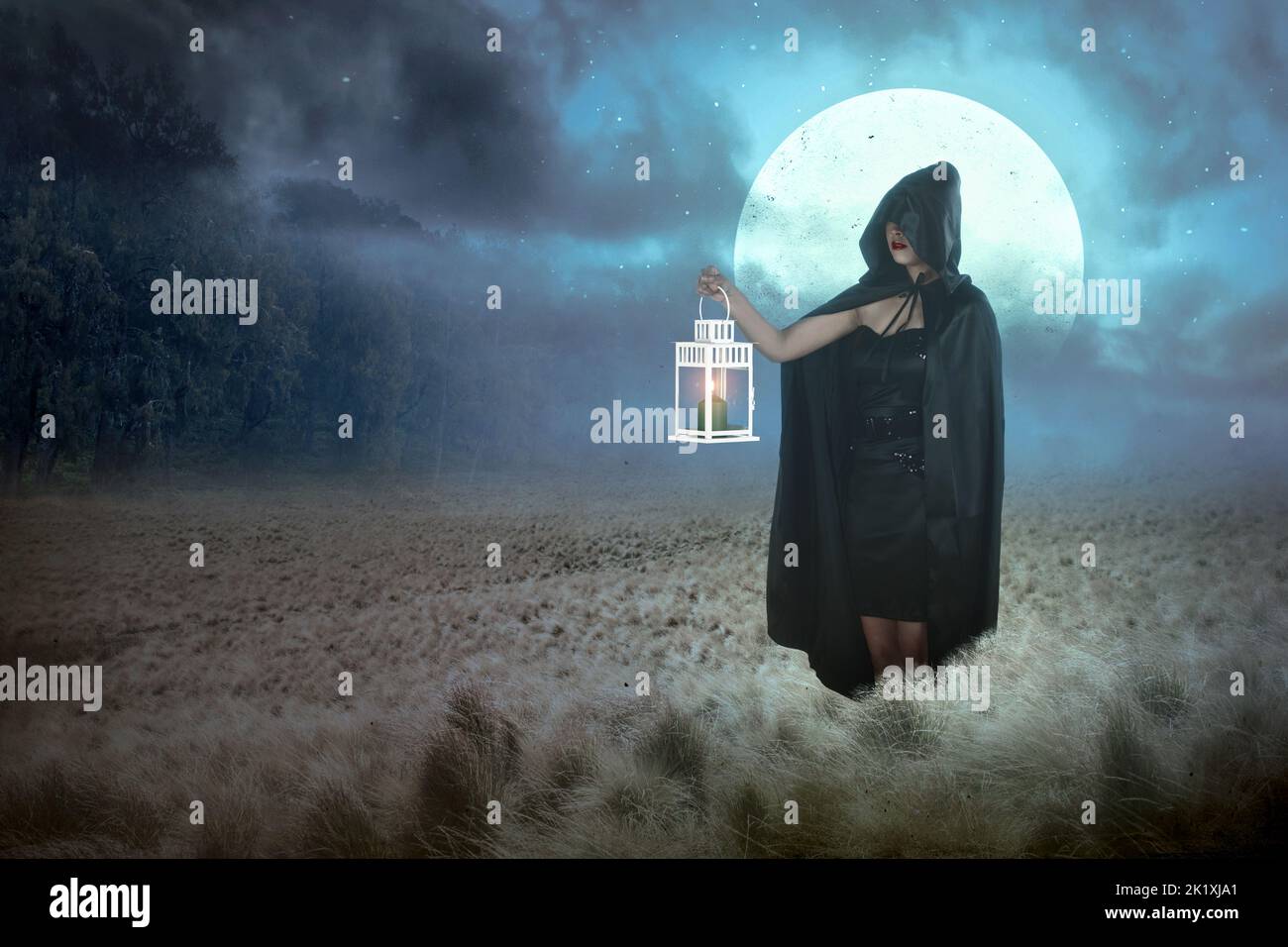Asian witch woman with a black cloak holding a lantern standing on the ...