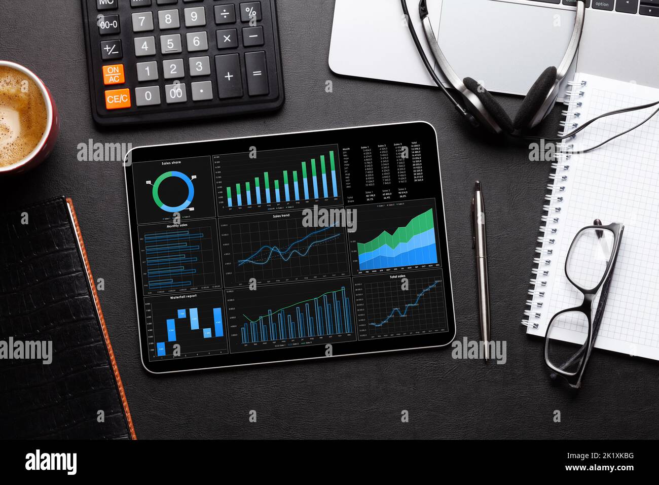 Tablet with business reports and charts, coffee cup and office supplies on desk. Top view flat lay Stock Photo