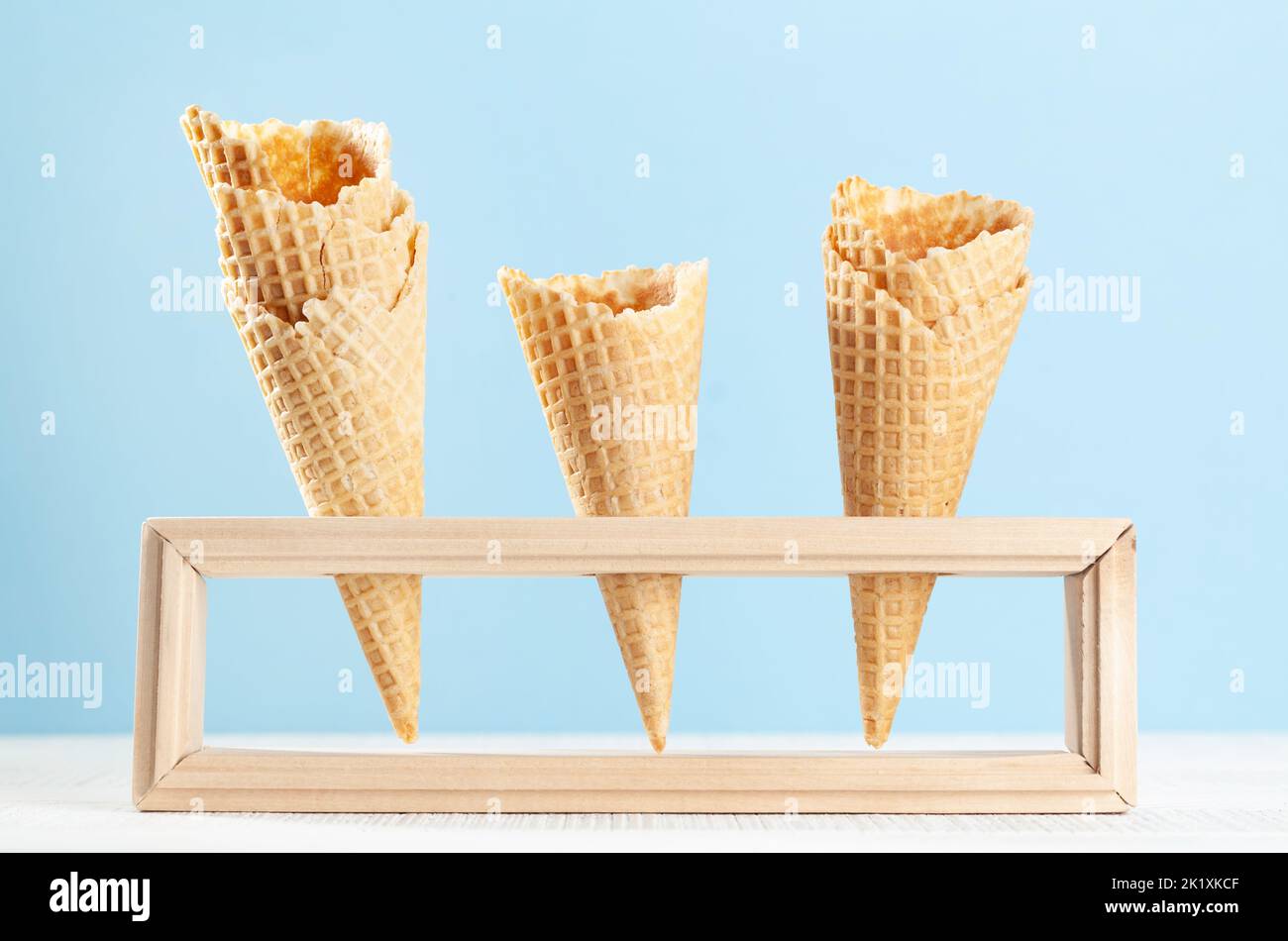 Empty ice cream waffle cones in wooden stand Stock Photo