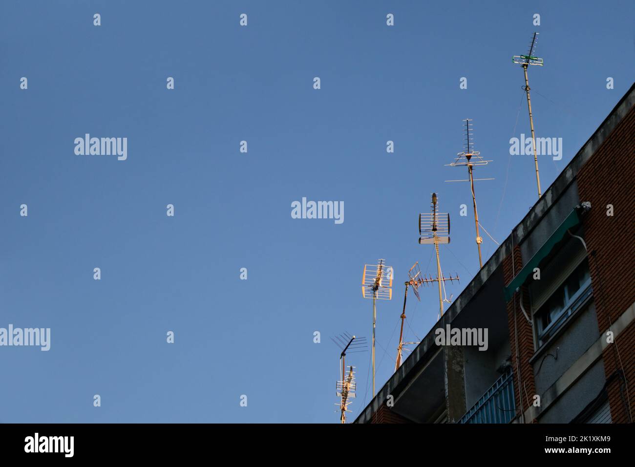 View of the roof of a residential building that has many antennas oriented towards the nearest DTT and DAB broadcasting center Stock Photo
