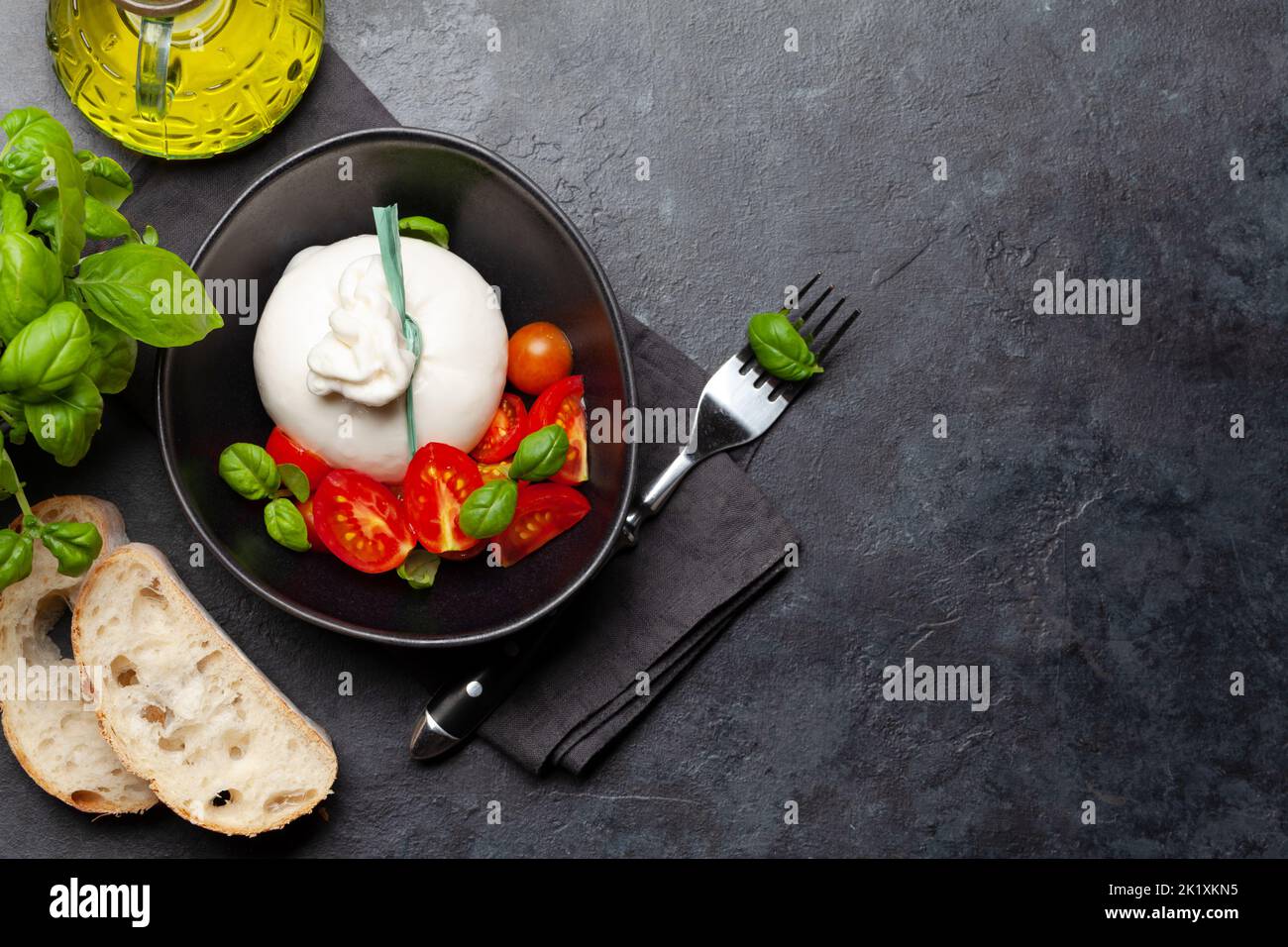 Burrata cheese, various tomatoes and olives. Italian cuisine. Flat lay with copy space Stock Photo