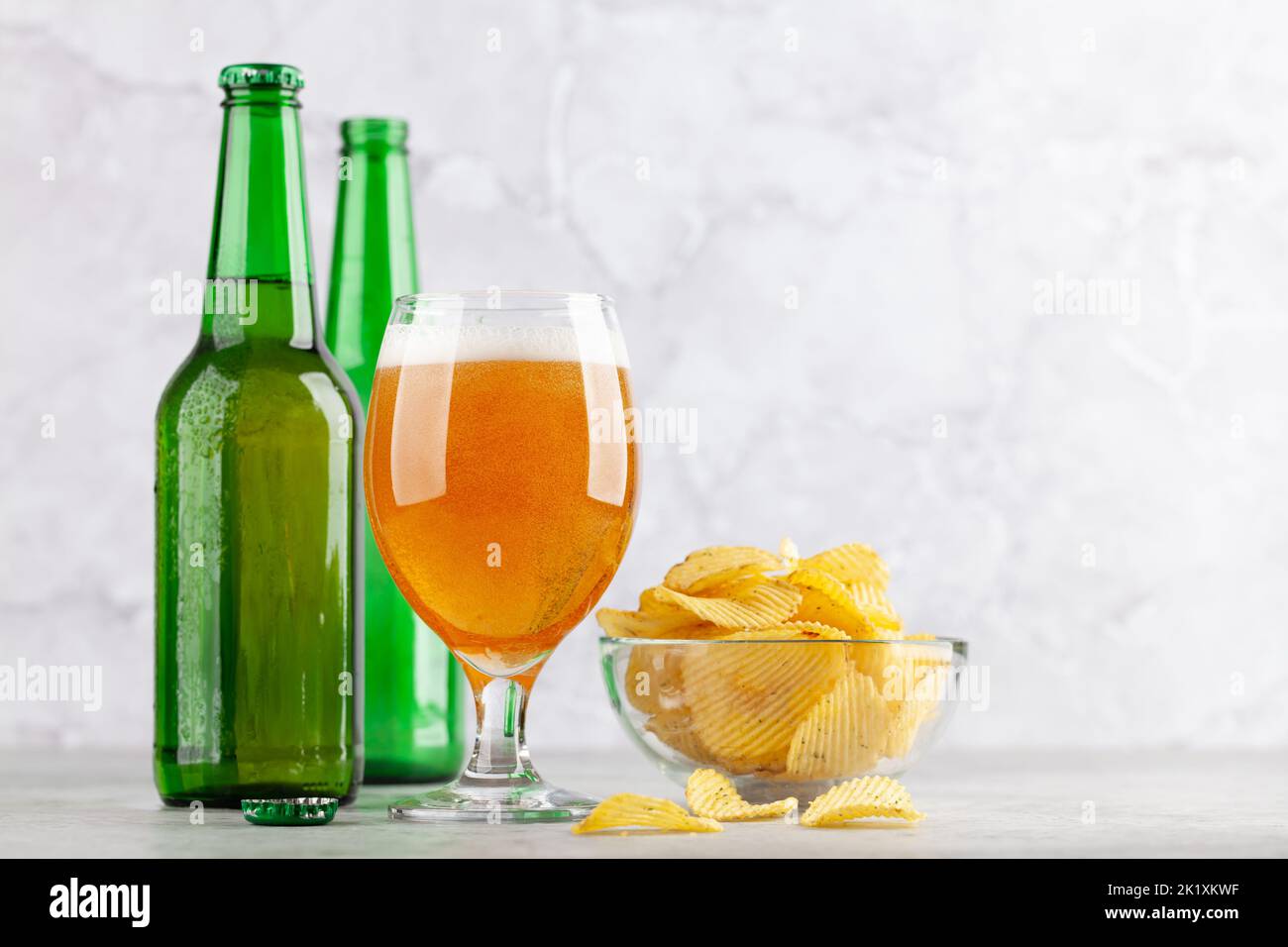 Beer glass, beer bottles and potato chips. With copy space Stock Photo