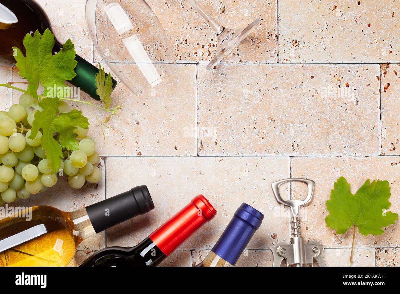 Various wine bottles, glasses and corkscrews on stone table. Flat lay with copy space Stock Photo