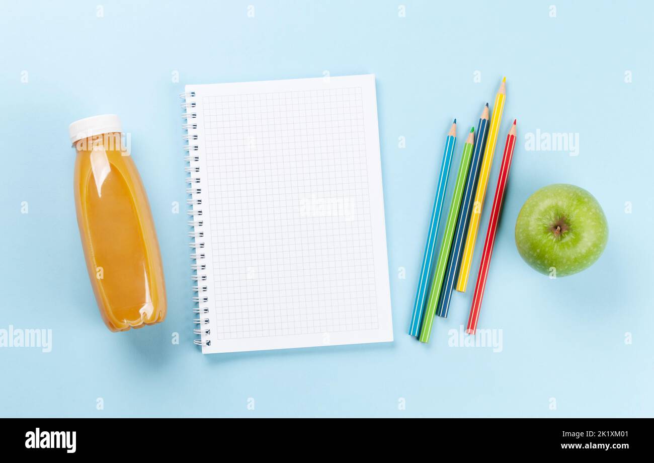 Blank notepad and colorful pencils. Flat lay over blue background with copy space Stock Photo