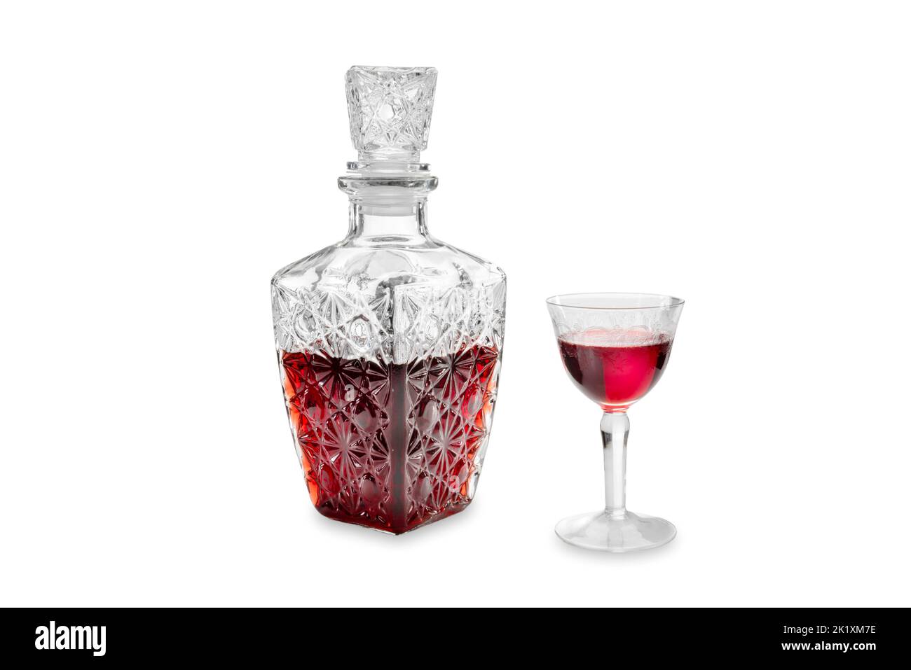 Red Cherry liquor in glass bottle decorated with vintage glass with decorative engravings isolated on white, clipping path Stock Photo