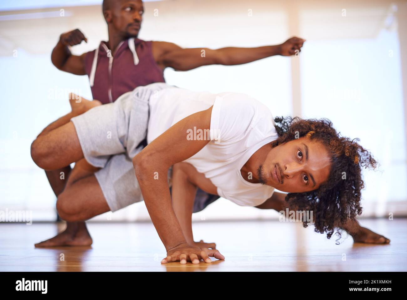 Keeping fit with capoeira. two young men practicing in a dance studio. Stock Photo