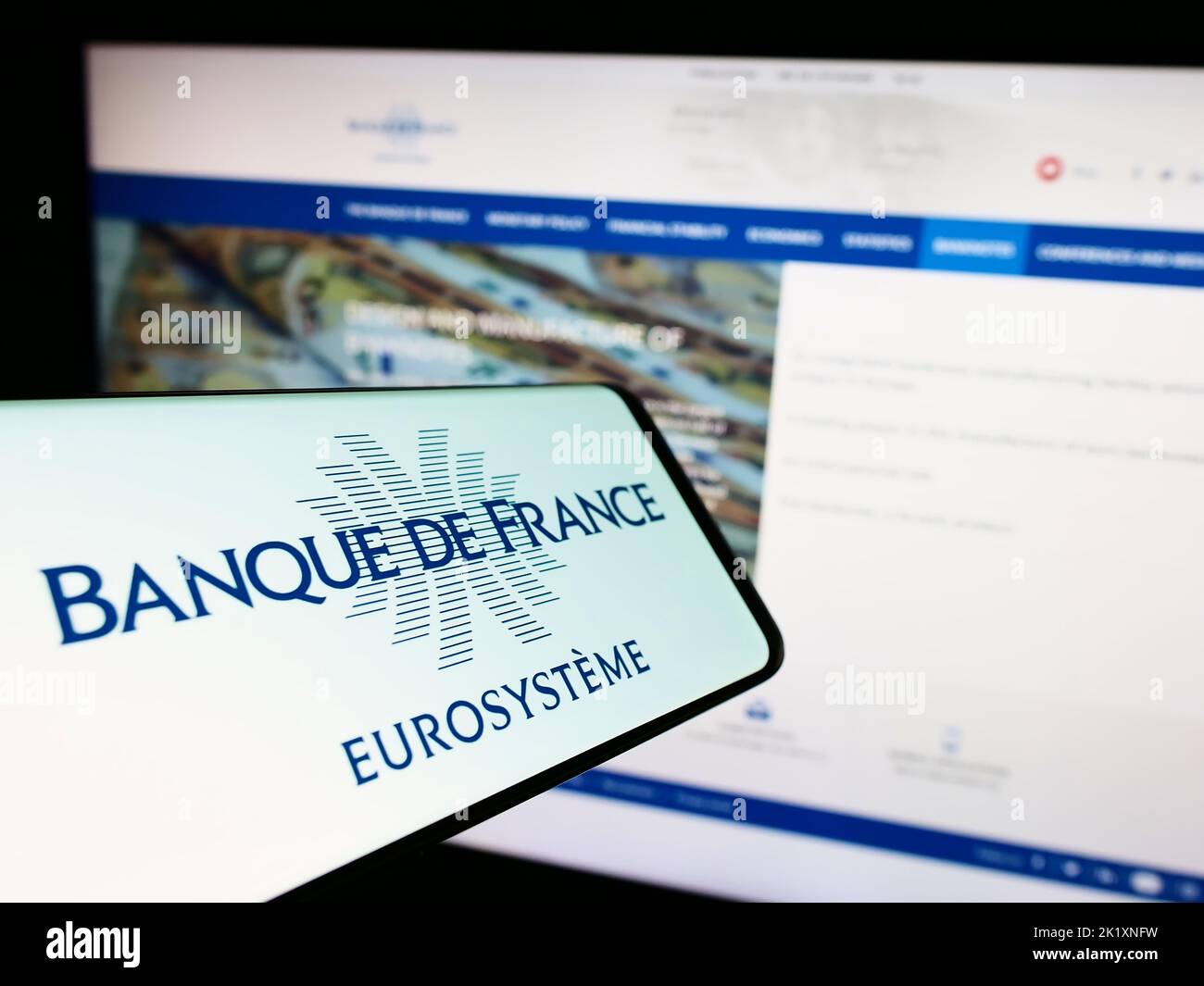Smartphone with logo of French central bank Banque de France on screen in front of website. Focus on center-right of phone display. Stock Photo