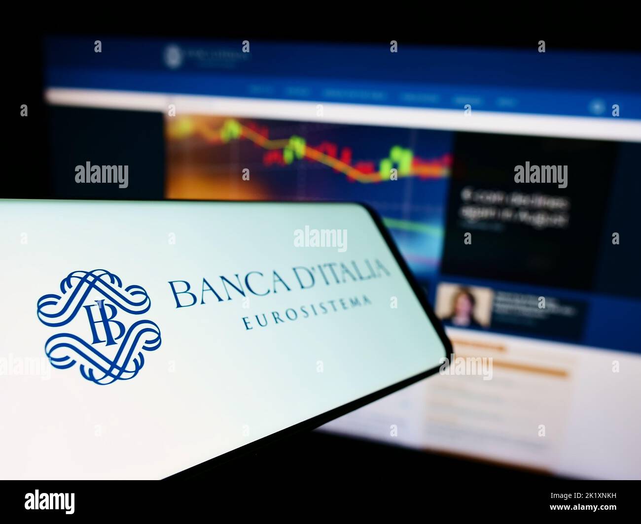 Mobile phone with logo of Italian central bank Banca d'Italia on screen in front of website. Focus on left of phone display. Stock Photo