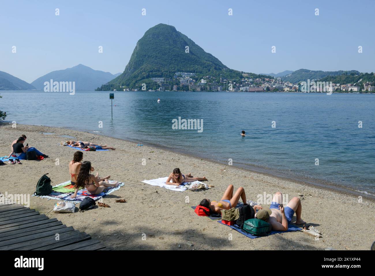 Lugano, Switzerland - 19June 2022: people sunbathing on the beach at Lugano on Switzerland Stock Photo