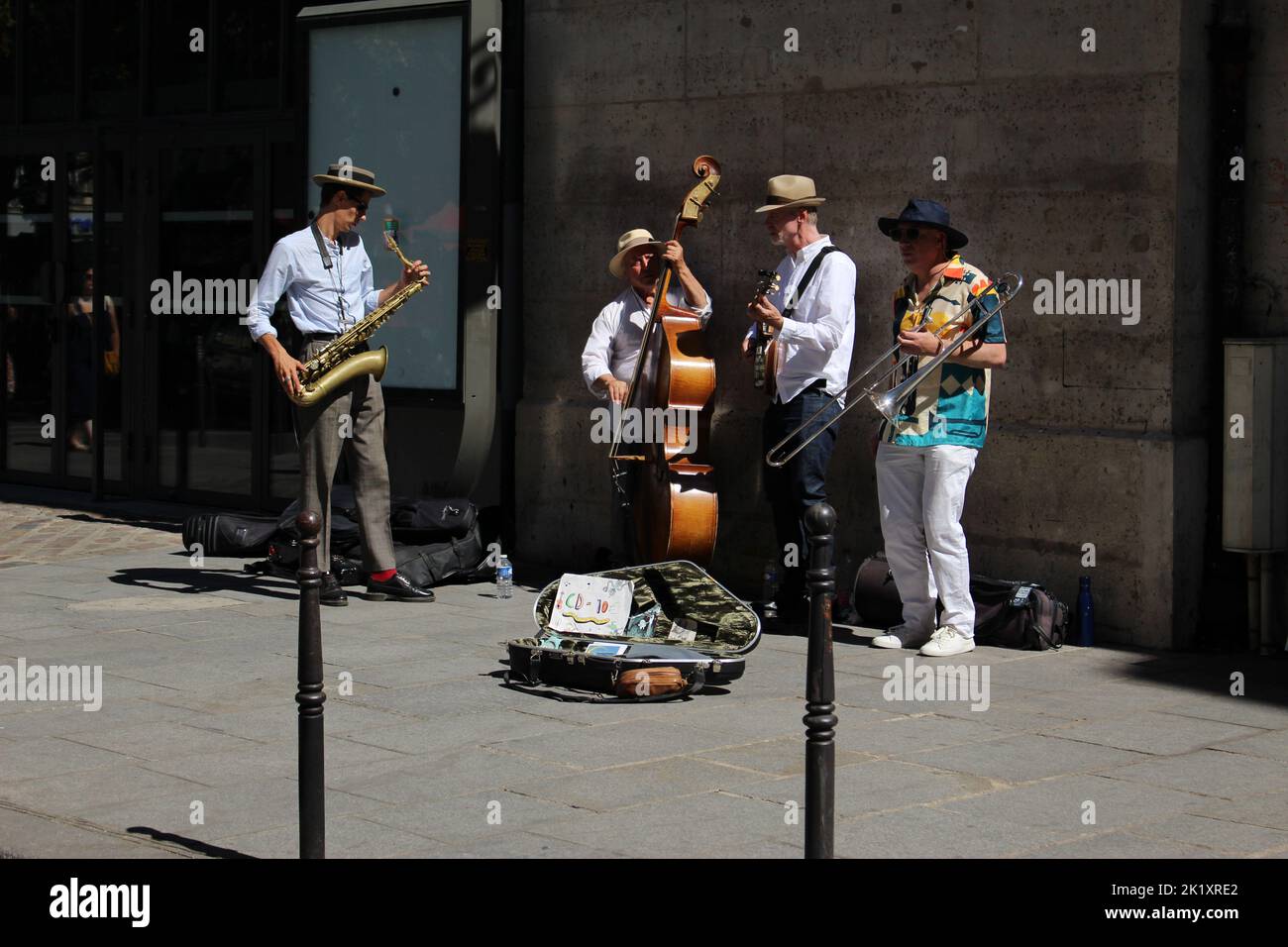 Four man band (quartet) busking on a Parisian street in summer. Concept for street musicians occupation Stock Photo