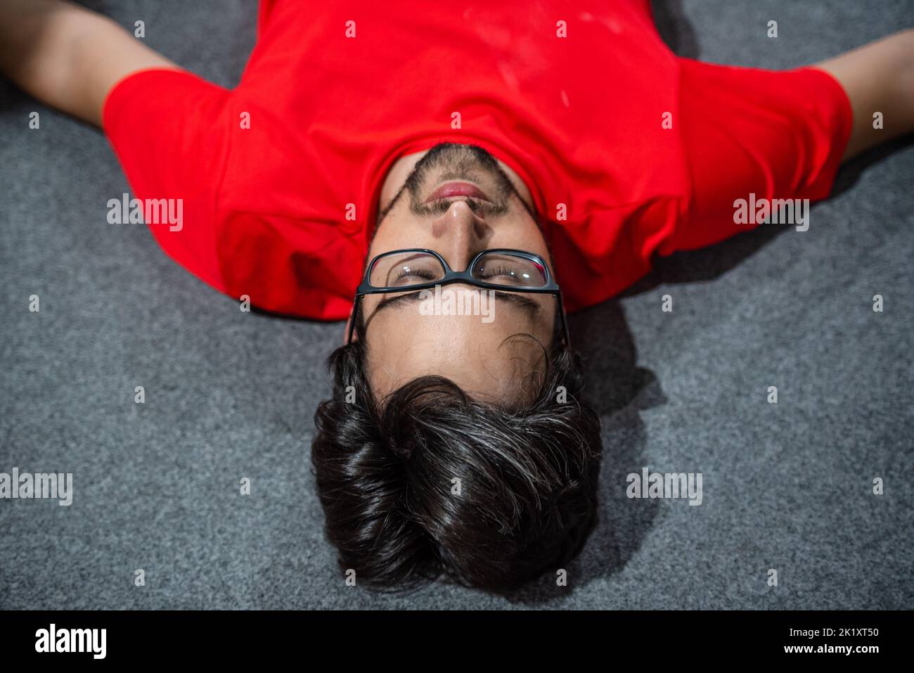 Exhausted man lying on the ground Stock Photo - Alamy