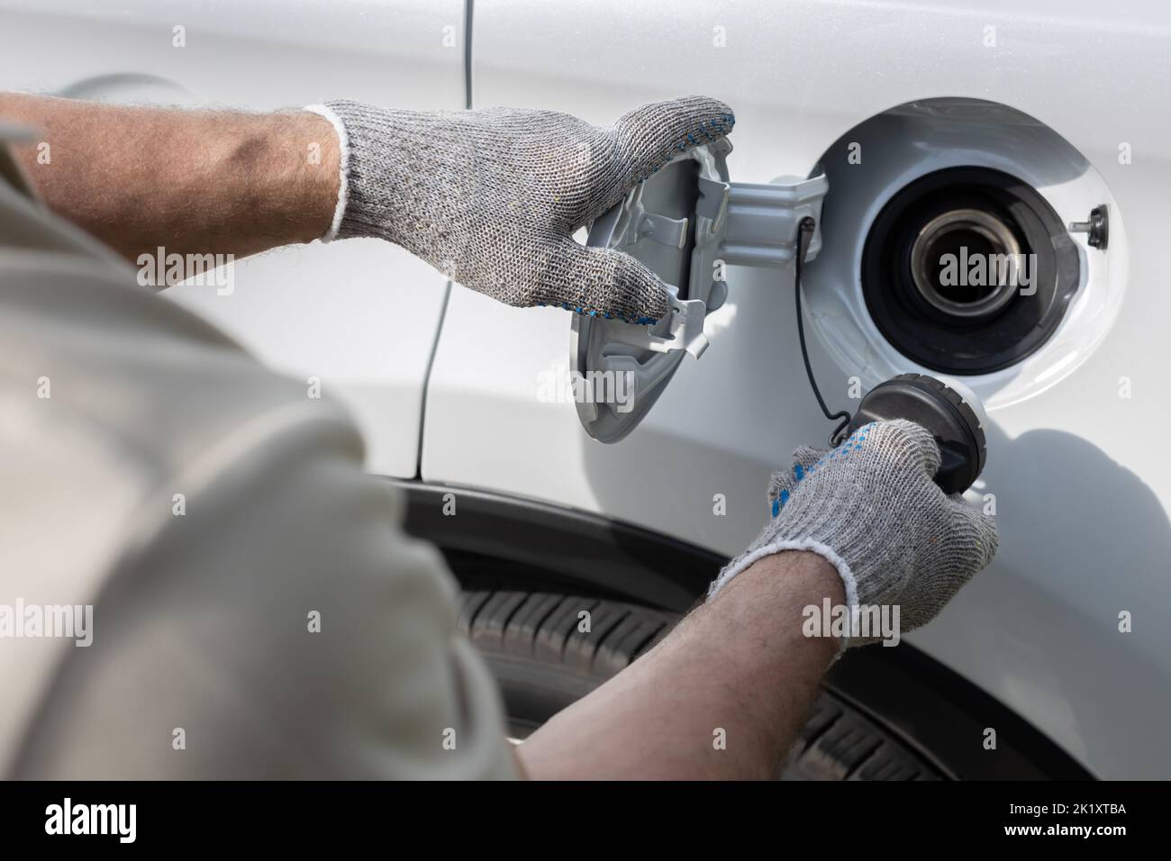 man opens the hatch of the gas tank of the car. driver opens gas tank
