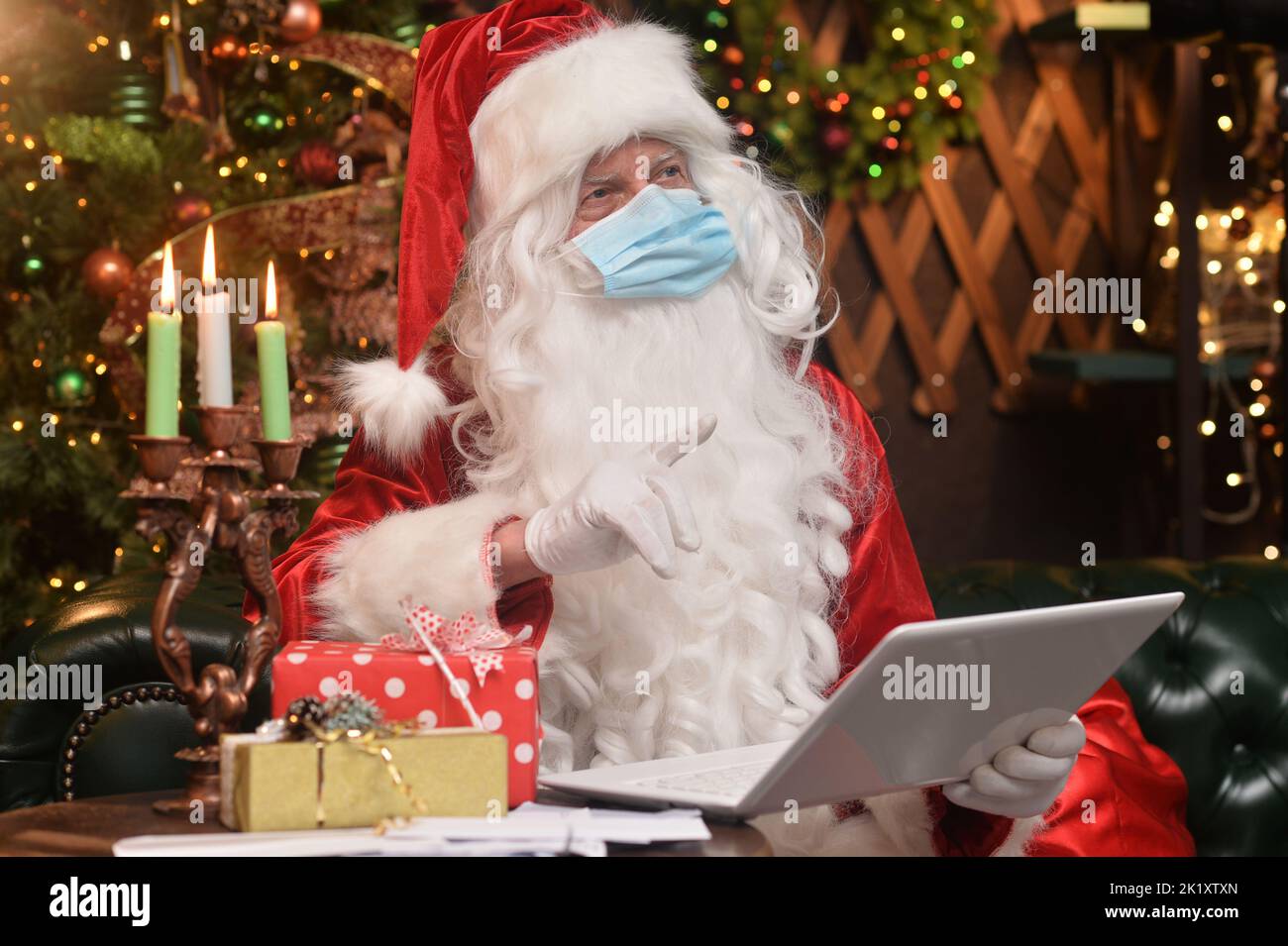 Santa Claus in a traditional costume sits with a laptop Stock Photo Alamy