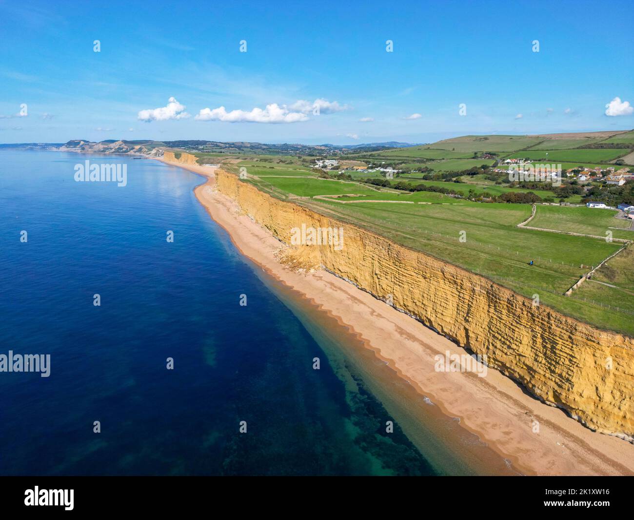 View from the air of the golden sandstone cliffs at hive beach at Burton Bradstock on the Dorset Jurassic coast on a hot sunny autumn day. Stock Photo