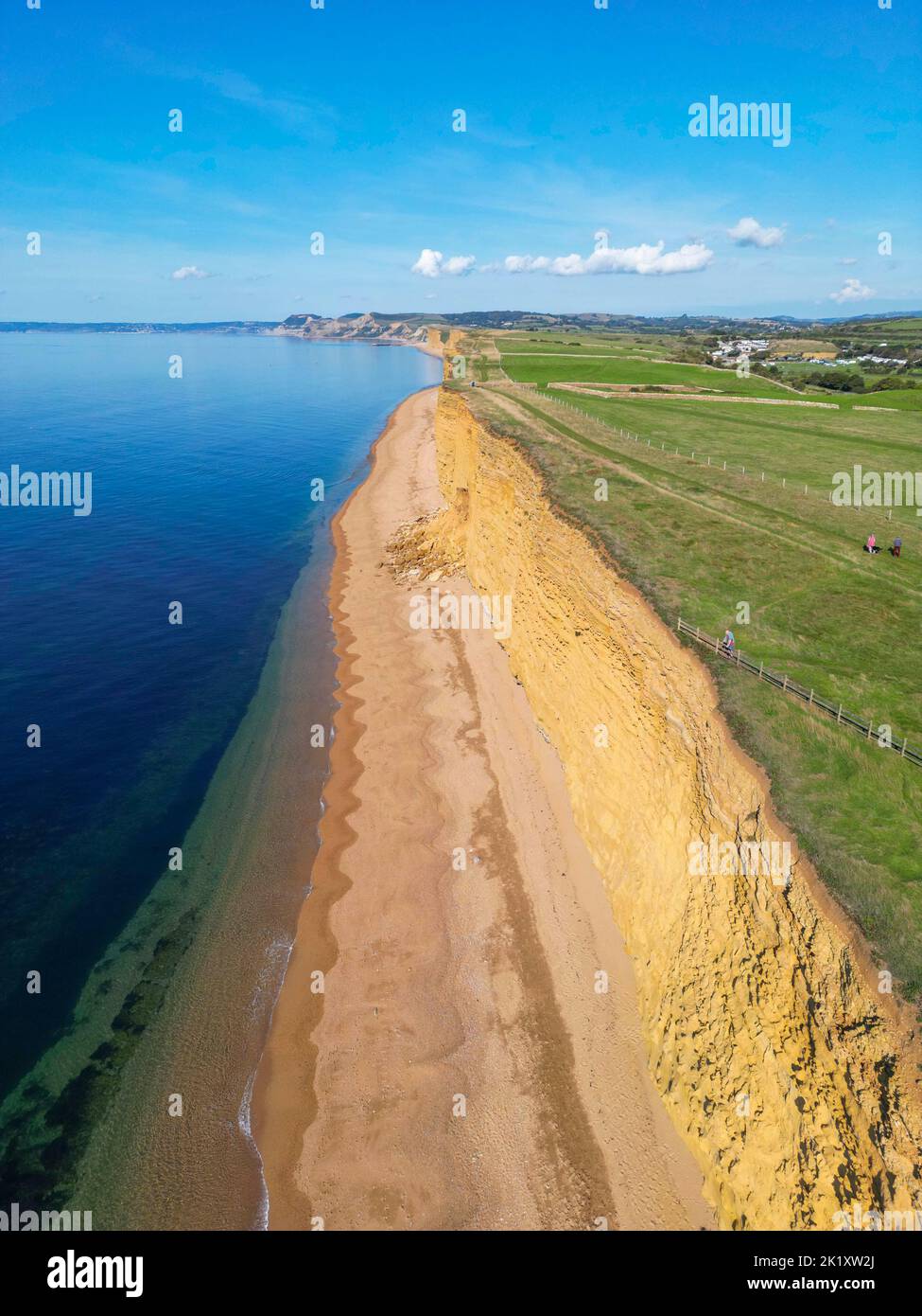 View from the air of the golden sandstone cliffs at hive beach at Burton Bradstock on the Dorset Jurassic coast on a hot sunny autumn day. Stock Photo