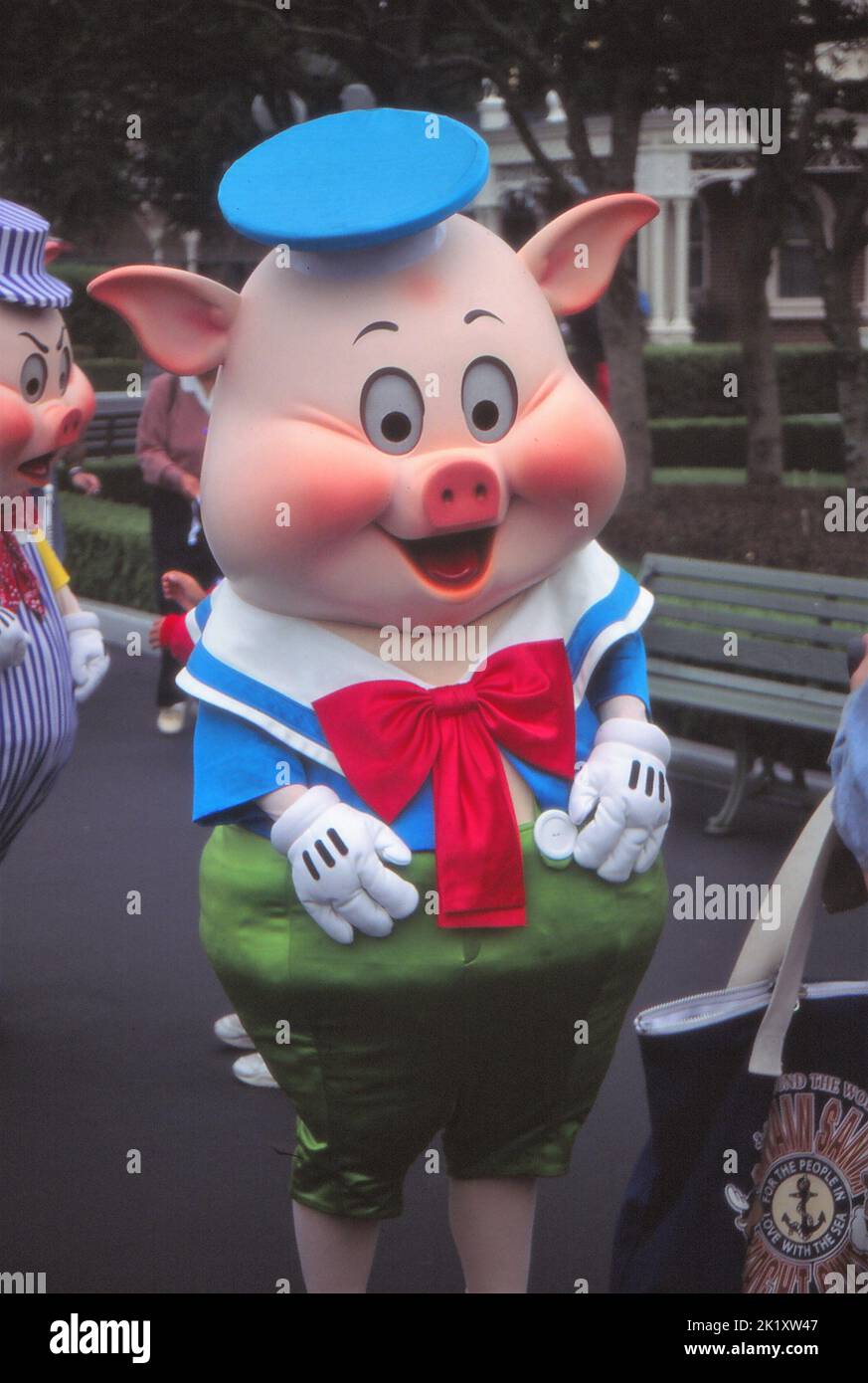 A vertical of a Fiddler pig at Tokyo Disneyland with sailor hat and red bow tie Stock Photo