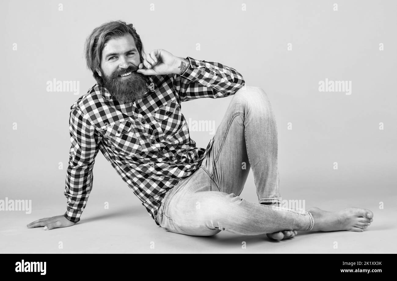 carefree and barefoot. male wearing checkered shirt. casual male