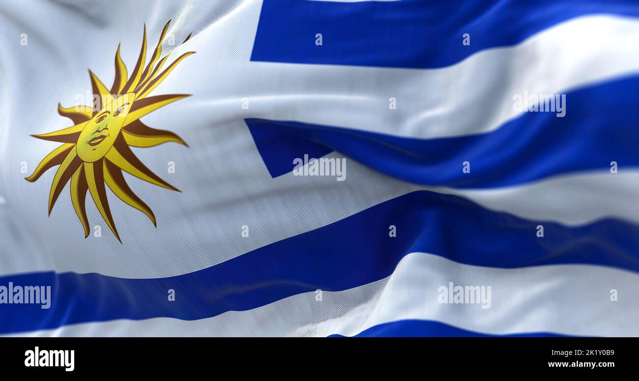 Close-up view of Uruguay national flag waving in the wind. The Oriental Republic of Uruguay is a country in South America. Fabric textured background. Stock Photo