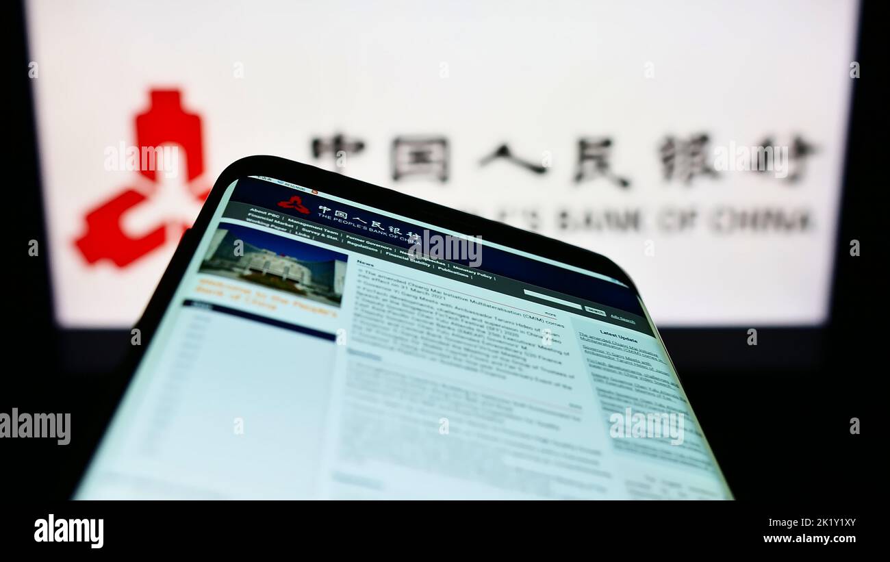 Mobile phone with website of financial institution People's Bank of China on screen in front of logo. Focus on top-left of phone display. Stock Photo
