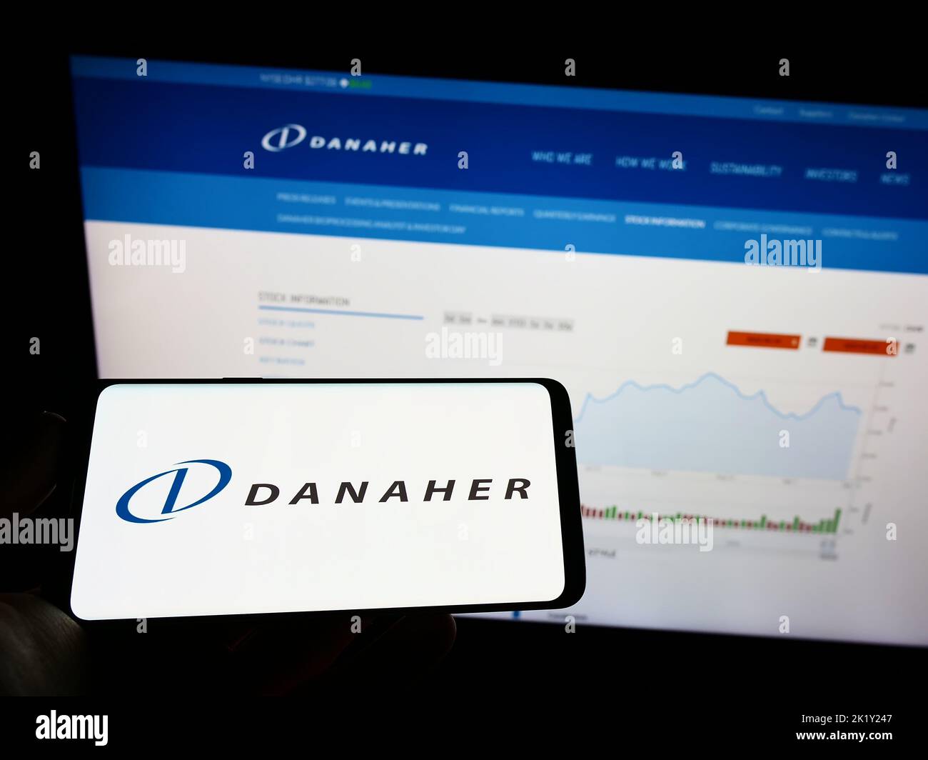 Person holding cellphone with logo of US conglomerate Danaher Corporation on screen in front of business webpage. Focus on phone display. Stock Photo