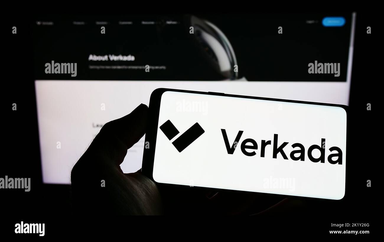 Person holding smartphone with logo of US security systems company Verkada Inc. on screen in front of website. Focus on phone display. Stock Photo