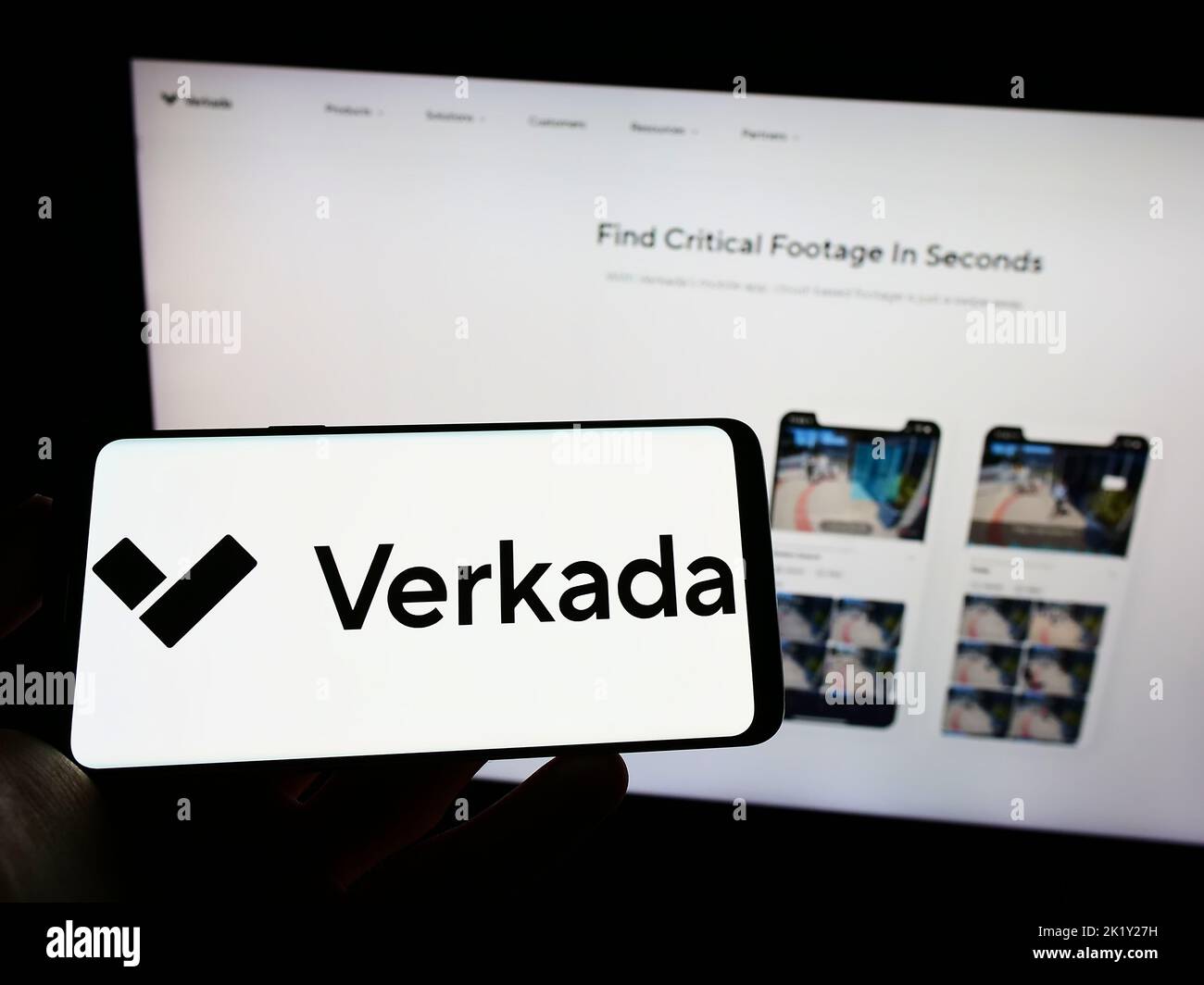 Person holding cellphone with logo of US security systems company Verkada Inc. on screen in front of business webpage. Focus on phone display. Stock Photo