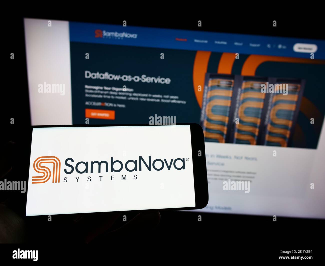 Person holding cellphone with logo of US AI company SambaNova Systems Inc. on screen in front of business webpage. Focus on phone display. Stock Photo
