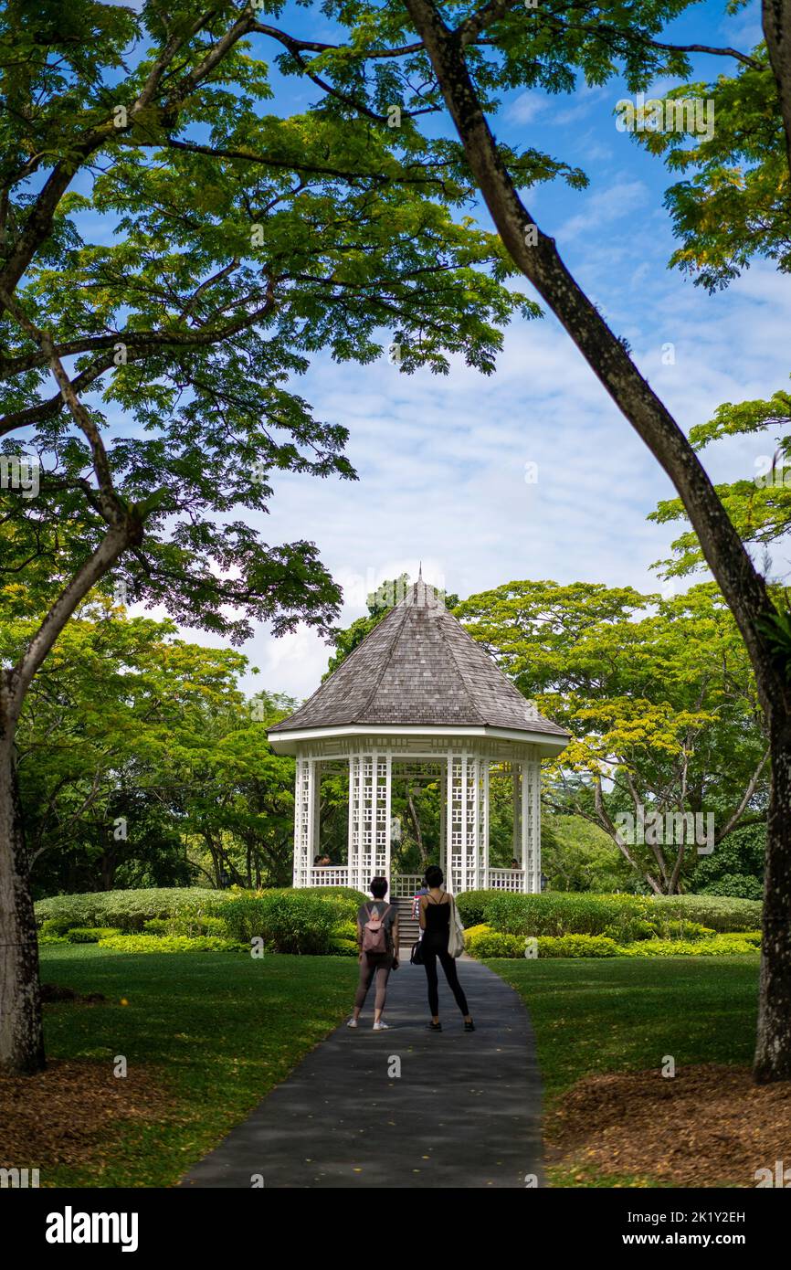 Couple standing on path leading to the Bandstand, an octagonal rotunda in Botanical Gardens, Singapore Stock Photo