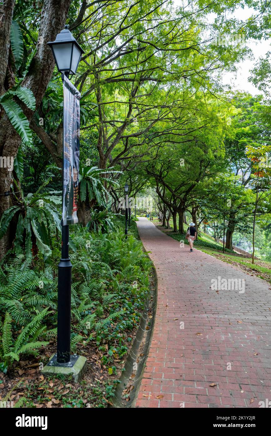 Person in distance walking on footpath in Fort Canning Park, Singapore Stock Photo