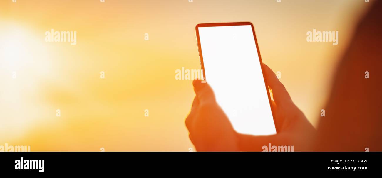 Woman hands holding smartphone at outdorrs in the evening Stock Photo